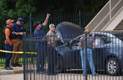 A law enforcement agents search a vehicle near the scene of a shooting at a U.S. Immigration and Customs Enforcement office in Dallas. 9-24-25